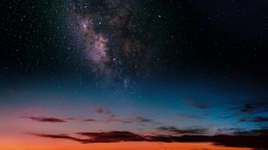 Mor eğimli günbatımı gökadası ve alacakaranlıkta yıldızlar, sakin kozmik manzara