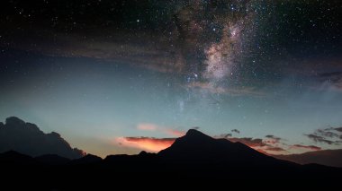 Galaksinin altındaki bir dağın arka planında güneş batarken yıldızlı bir gece, dağ gecesi duvar kâğıdı.