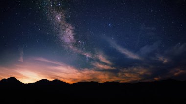 Günbatımında gökyüzü arkaplanı kozmik gece ile bir dağın tepesinde, alacakaranlıkta, manzaralı galaksi manzarası