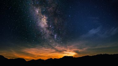 Günbatımında gökyüzü arkaplanı kozmik gece ile bir dağın tepesinde, alacakaranlıkta, manzaralı galaksi manzarası