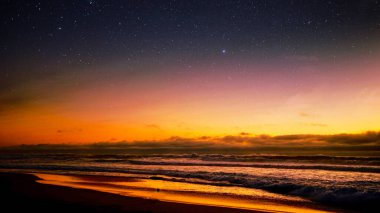 Gün batımında plaj manzarası yıldızlı gökyüzünün altında, sakin deniz manzarası duvar kağıdı