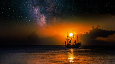 Günbatımında Samanyolu Galaksisi 'nin altında, deniz manzaralı arka planda yelkenli.