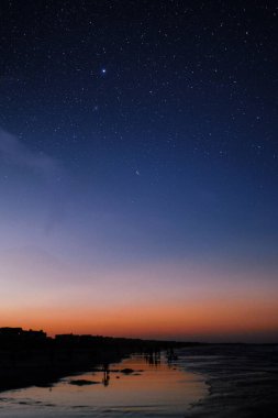 Gün batımı gökyüzü ve akşam yıldızlı bir gece, telefon için huzurlu bir kozmik manzara.