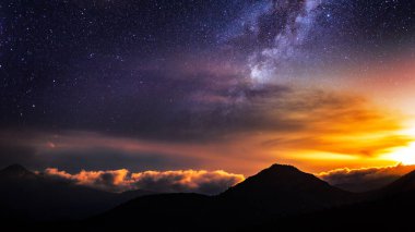 Yıldızlı gece ve galaksi gökyüzü altında gün batımı dağ manzarası, masaüstü duvar kağıtları için sakin bir dağ galaksisi arka planı