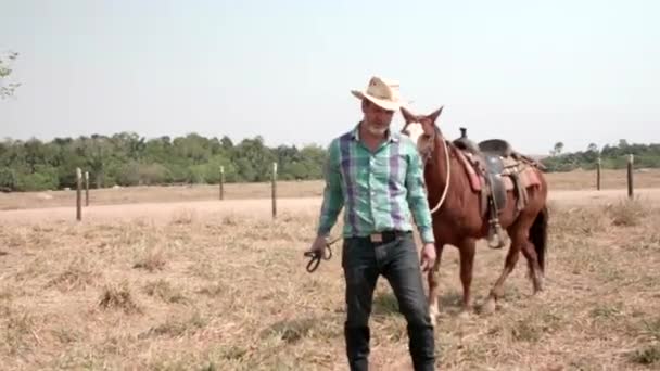 牛仔牵着他的马和相机走在前面 — 图库视频影像