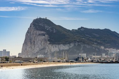 La Linea de la Concepcion 'daki Playa Poniente' nin geniş manzarası, sakin suları ve ufukta Cebelitarık Kayası var..