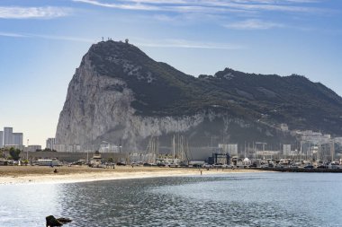 La Linea de la Concepcion 'daki Playa Poniente' nin geniş manzarası, sakin suları ve ufukta Cebelitarık Kayası var..