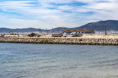 11 Kasım 2025, Algeciras, İspanya: Algeciras limanındaki liman inşaatı sırasında liman takviyesi ve liman genişlemesini destekleyen ağır makineler ile deniz mühendisliği faaliyetleri.