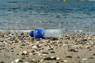 11 Kasım 2011, Algeciras, İspanya: Okyanus kirliliği ve kıyı şeridi boyunca meydana gelen çevresel etkiyi vurgulayarak, su kenarındaki kumlu bir sahilde atılmış bir plastik şişenin editörel görüntüsü.