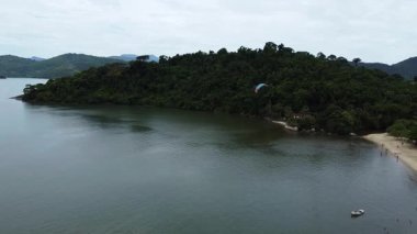 Brezilya 'da, Paraty Körfezi' nin, küçük adaların ve Paraty 'deki sık ormanlarla kaplı dağların çarpıcı görüntüsüyle yüzen ikili paraşütçüler.