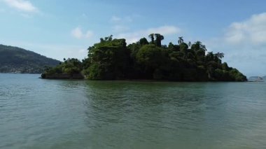 Angra dos Reis Körfezi 'ndeki küçük tropikal ada Ilha do Coqueiro' ya doğru yavaş bir insansız hava aracı yaklaşımı. Yoğun Atlantik yağmur ormanlarıyla kaplı.