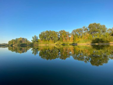 Suya yansıyan ağaçlarla Ural Nehri