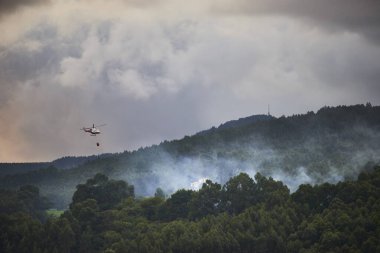 Bir itfaiye helikopteri Castro Urdiales, Cantabria 'da yangını söndürmeye çalışıyor.