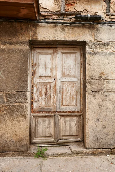 Eski girişi ve ahşap kapısı olan taş duvar.