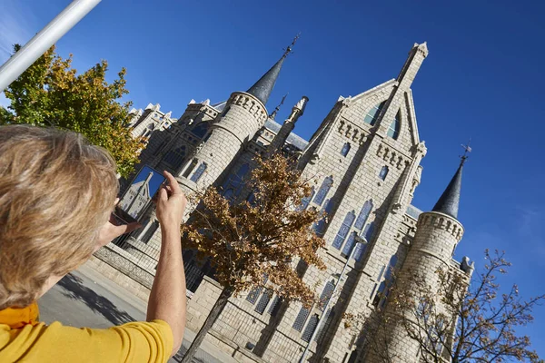 Kadın, Palacio Episcopal, Astorga, Len Eyaleti, Castilla y Leon, İspanya, Avrupa 'nın akıllı telefonuyla fotoğraf çekiyor.