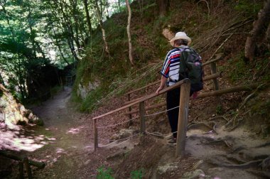 Sırt çantalı ve şapkalı orta yaşlı kadın yürüyor, Baquedano, Navarra, İspanya, Avrupa