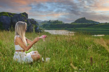 Sarışın kız şafakta meditasyon yapıyor.