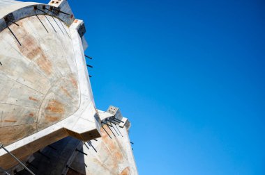 Arka planda mavi gökyüzü olan beton bir yapının ayrıntıları