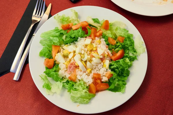 Haşlanmış yumurta, domates pilavı ve jambonlu salata.