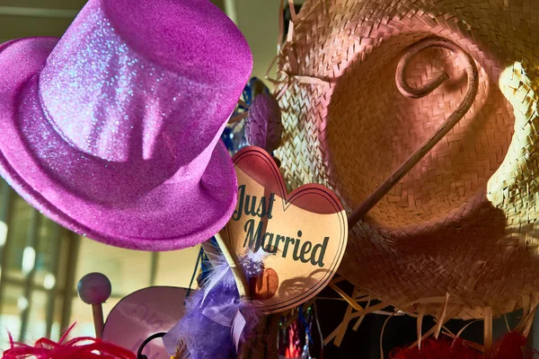 Kalbin üzerinde pembe bir parti şapkasının ayrıntıları ve arka planda da bir hasır şapka var.