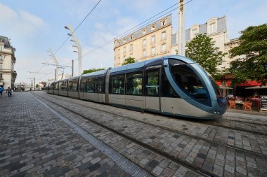 Modern tramvay tarihi bir şehir caddesinde ilerliyor, çağdaş toplu taşımacılığı geleneksel Avrupa mimarisi ile harmanlıyor