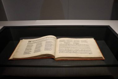 Camların altında sergilenen tarihi ve kültürel değerini vurgulayan antika bir kitap..