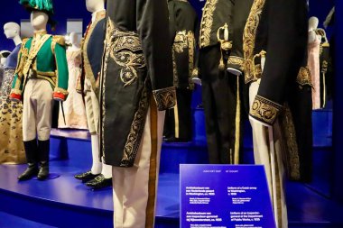 Müzede, geçmiş yüzyılların resmi erkek giyim tarzını temsil eden tarihi giysiler giymiş erkek mankenler sergileniyor..