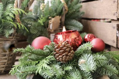 Doğal yosun, çam kozalağı ve kırmızı Noel süslemelerinin yer aldığı şenlikli bir arka plan. Yumuşak kompozisyon, tatil temaları için uygun sıcak bir mevsimsel atmosfer yaratıyor. Bu görüntü dekoratif bir kış ya da Noel arkaplanı olarak iyi çalışır..