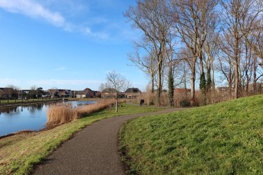 Kanal boyunca yol yeşil çimenler arasında kıvrılıyor.