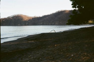 Kosta Rika 'nın canlı kıyı yaşamını, kırsal yolları ve verimli tropikal manzaraları, macerayı ve sükuneti zamansız klasik tarzda harmanlayan nostaljik bir analog film koleksiyonu.