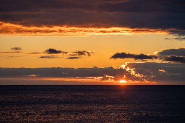Okyanus üzerindeki parlak güneş patlaması bulut şeridini, dramatik ışınları ve ışıldayan suyu, umut verici sinematik havayı, zengin sıcak tonları, yansıtıcı önplanı, metin için alanı aşıyor.