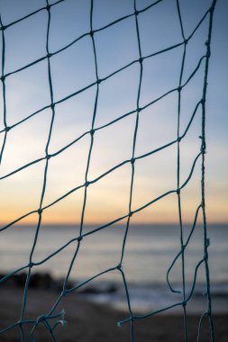 Seçici Odaklanma Gündoğumunda Balık Ağı. Yumuşak Pastel Gökyüzü ve Uzak Deniz, Önplan Ağı ve İp Keskin Detaylı, Arkaplan Bulanıklığı Bokeh