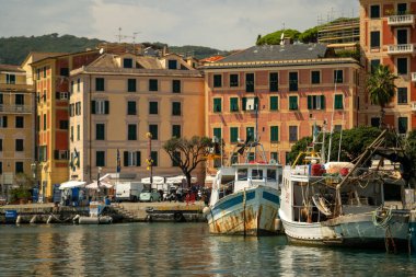 Meşgul rıhtım demirli tekneler, sandıklar ve ekipmanlarla dolu, sternler ve yaylar katmanlı bileşim oluşturuyor,