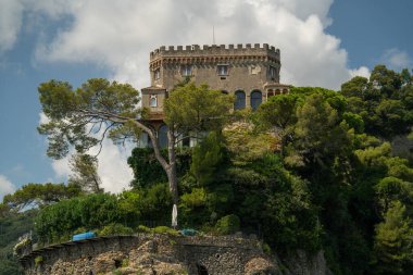 Deniz manzaralı yuvarlak taş kule. Çam koruluğu, dramatik bulut manzarası, panoramik.
