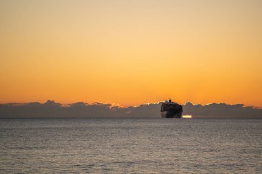 Sakin suların ve kargo gemisinin üzerinde gün doğumuyla sakin bir deniz yolculuğu. Gün doğumunda sakin bir deniz macerası. Kargo gemileri huzurlu şafak denizlerinde süzülürken.