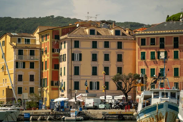 Güneşli rıhtımlar Pastel cepheleriyle ve tek ağaçlı gölgelerle rıhtım, demirli tekneler ve nazikçe