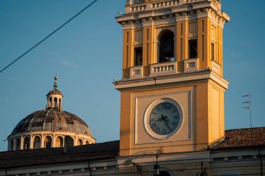 Tarihi saat kulesi ve katedral kubbesi parma, süslü kornişler, açık gökyüzü ve klasik şehir mimarisini ön plana çıkaran şehir panoramasıyla altın saat ışığıyla yıkandı..