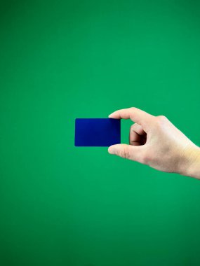 Yeşil arka planda koyu mavi banka kartı, modern finans ve elektronik ödemeler kavramı