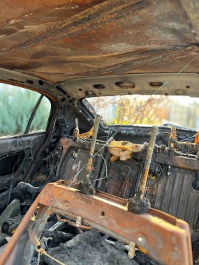 Yanmış arabanın içi ve koltuğu erimiş ve yanmış panelleri gösteriyor.