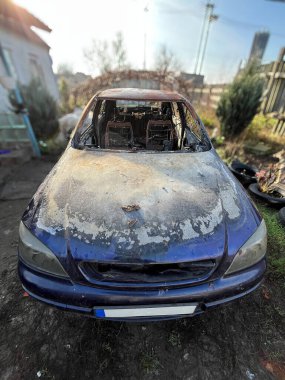 Yanmış kapüşonlu ve tamponlu yolcu aracının ön görüntüsü.