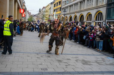 Krampus 'un büyük inek çanları taşıyan sanatçısı, 8 Aralık 2024' te Almanya 'nın Münih kentindeki Krampuslauf' a katılıyor. Yılda yaklaşık 300 Krampus yaratığı Aziz Niklas gelenekleriyle bağlantılı folklor etkinliğinde yürüyor.