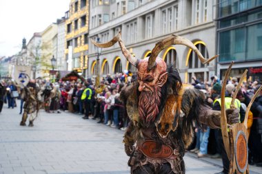Krampus halk yaratığı Münih, Almanya 'daki ünlü Krampuslauf geçit töreninde - 8 Aralık 2024. Geçit töreni, fantezi kostümlü yaklaşık 300 aktörü bir araya getirdi. Yaratıklar St. Nicholas gelenekleriyle ilgili geleneksel Alp folklorunu canlandırıyorlar.    