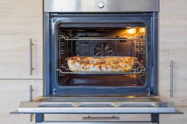 Ev yapımı lazanya fırında makarna, et sosu ve peynir katmanları ile fırında pişiyor. Eriyor ve altın bir finişe kadar pişiriliyor..