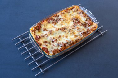 Ev yapımı lazanya, eritilmiş peynir ve et sosunu cam bir kabın içinde servis etmeye hazır..