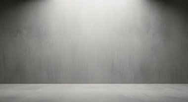 Minimalist stüdyo sahnesi. Gri bir duvar ve yukarıdaki spot ışıkları temiz zemine yumuşak bir ışık yansıtıyor.