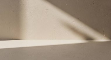 Modern bir yüzeyin köşesinde bulanık çizgiler ve yumuşak bej renkleri gösteren sessiz ve soyut bir kompozisyon.