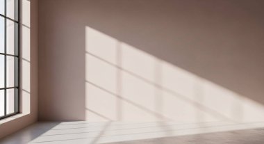 A softly lit empty room features a large window casting geometric shadows across a clean wall and floor, creating a calm modern space.