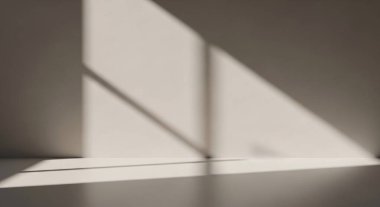 Sert köşegen ışık çizgilerinin yer ve duvarda gölgeler oluşturduğu kasvetli, gri bir iç mekan..