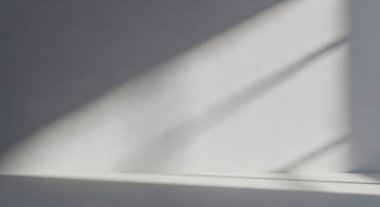 A quiet abstract image showing soft light crossing a smooth surface with diagonal shadows, creating a calm, minimal composition.