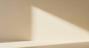 Temiz iç mimari yüzeyler boyunca sıcak bej tonlara ve keskin üçgen ışık huzmesine sahip soyut bir görüntü..